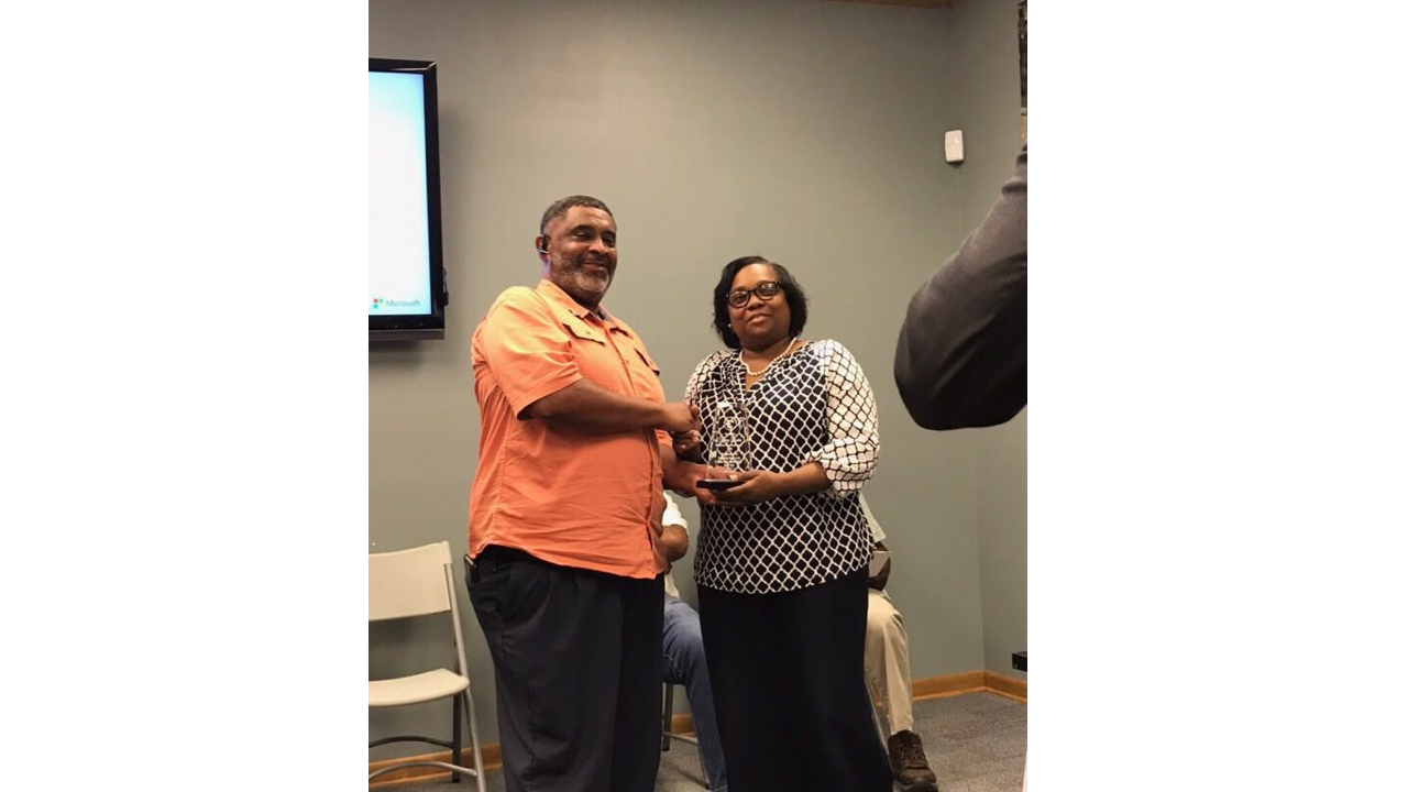 Ivan Smith, director of the Hinds County School District, presents an award of appreciation to Tammy Rankin, Entergy Mississippi customer service representative.